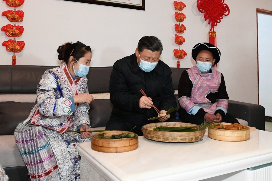 2021年2月3日下午，習(xí)近平在貴州畢節(jié)市黔西縣新仁苗族鄉(xiāng)化屋村苗族村民趙玉學(xué)家，同一家人邊聊家常邊制作當(dāng)?shù)貍鹘y(tǒng)節(jié)日食品黃粑。新華社記者 李學(xué)仁 攝