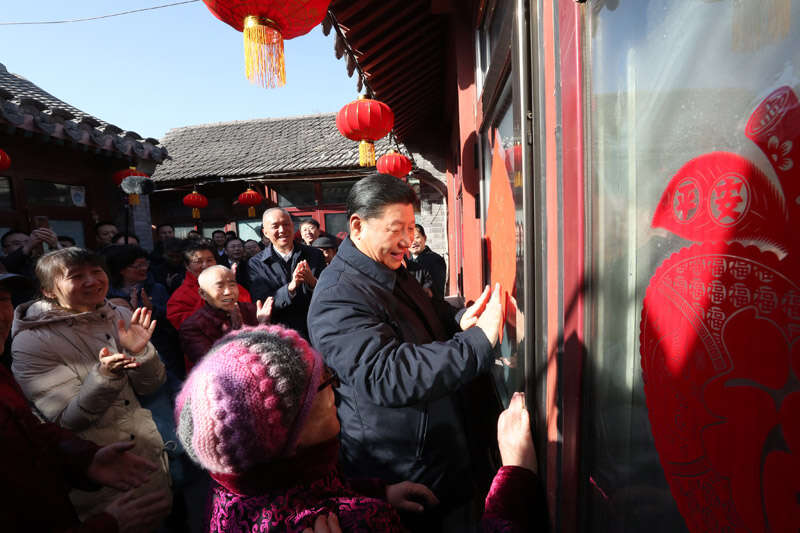 2019年2月1日上午，習(xí)近平在北京前門東區(qū)草廠四條胡同32號(hào)院，高興地拿起一幅“?！弊?，親自貼到門上，給這里的老街坊們拜年。新華社記者 鞠鵬 攝