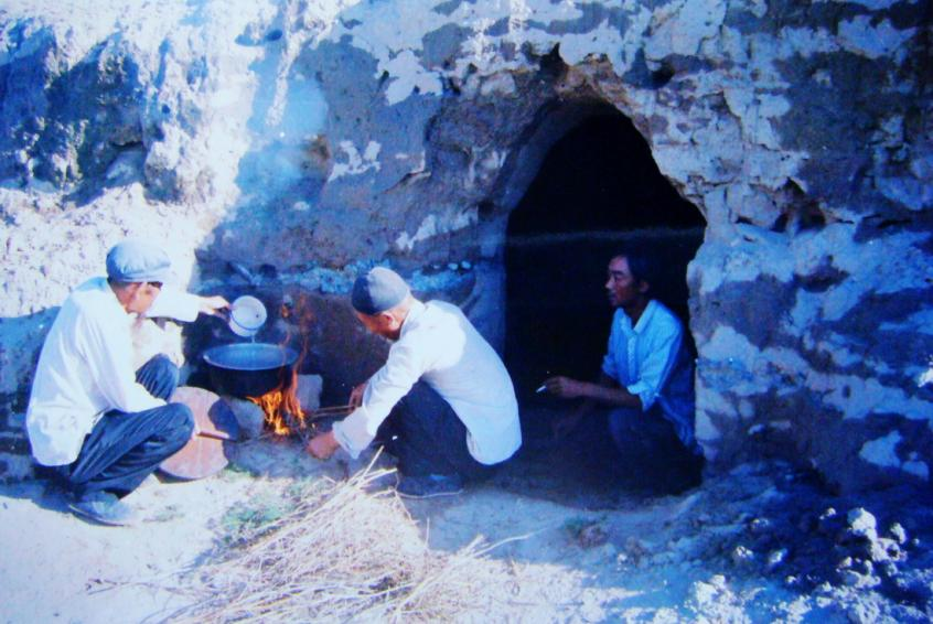 1983年，“六老漢”一代治沙人在“地窩子”生活做飯。新華社發(fā)（八步沙林場供圖）