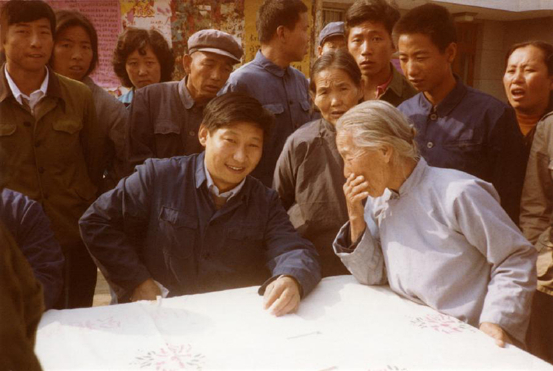 1983年，時(shí)任河北正定縣委書記的習(xí)近平（前排居中），臨時(shí)在大街上擺桌子聽取老百姓意見。